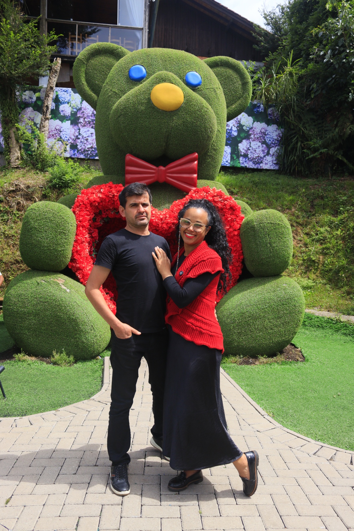 Verônica e Luís em frente ao urso de flores